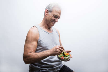 Senior man holding bowl of salad