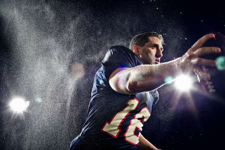 American footballer running with ballの写真素材