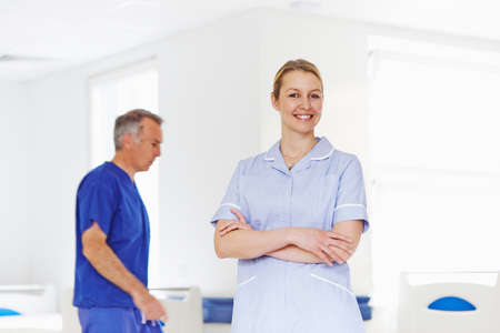 Portrait of nurse with doctor in backgroundの写真素材