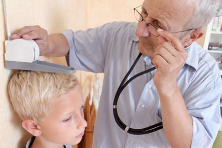Doctor measuring boy's heightの写真素材
