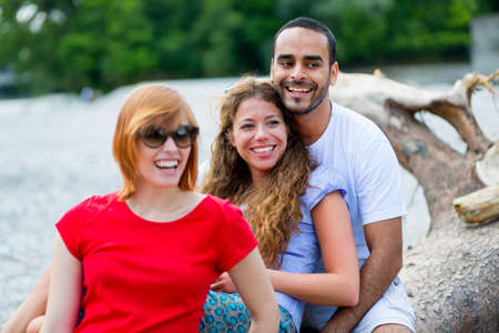 Three friends sitting on logの写真素材