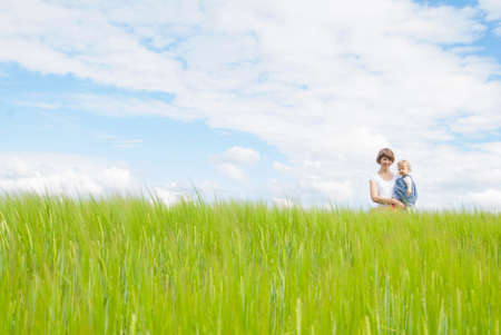 Mother holding daughter in fieldの写真素材