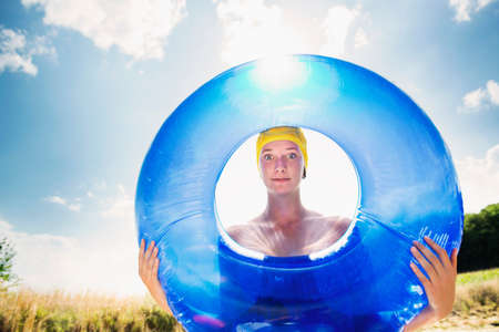 Fun portrait of adolescent girl holding rubber ringの写真素材