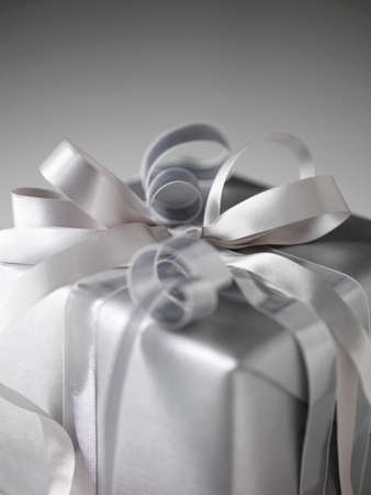 Still life with parcel wrapped in silver paper and ribbonsの写真素材