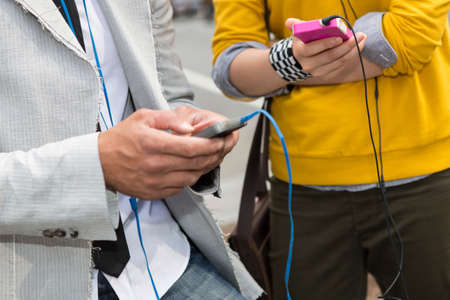 Close up of hands using mp3 playerの写真素材