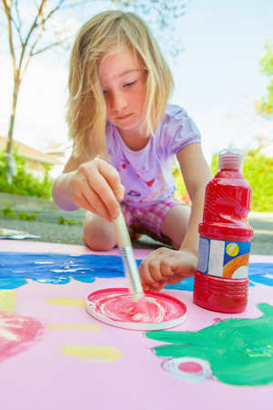 Girl painting with tempera on paperの写真素材