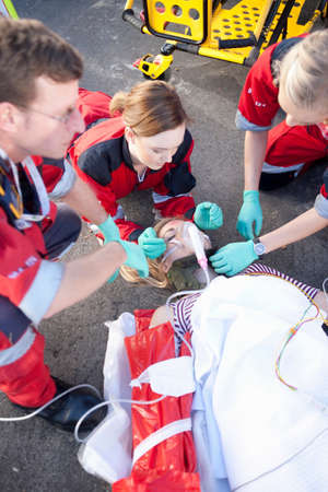 Three paramedics with patient on stretcher wearing oxygen maskの写真素材
