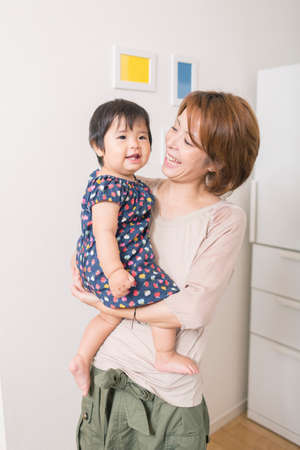 Mother smiling at baby in armsの写真素材