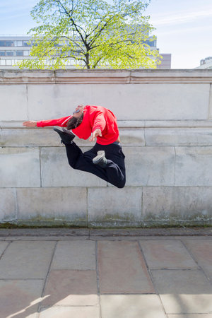 Young male dancer mid air in cityの写真素材