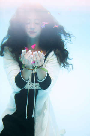 Mid adult woman with flowers, underwater
