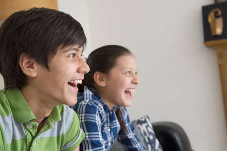 Brother and sister watching tvの写真素材