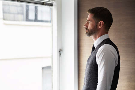 Portrait of businessman looking out of window