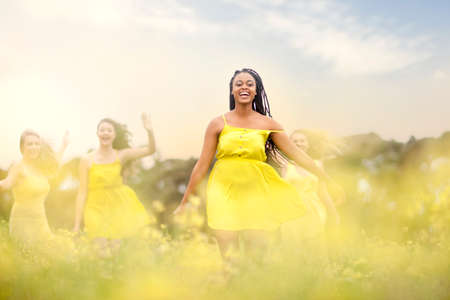 Girls in yellow dancing on meadow