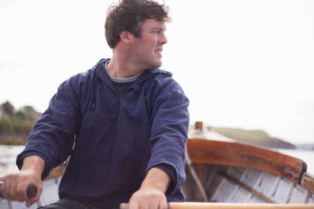 Portrait of man rowing in boat, Wales, UK