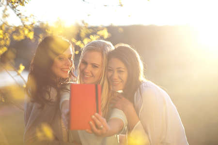 Three young women taking self portrait in parkの写真素材