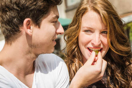 Young couple eating grapesの写真素材