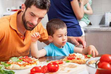 Father and son making homemade pizzaの写真素材