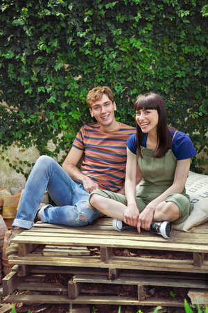 Couple sitting on wooden palettesの写真素材
