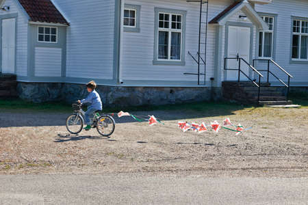 Boy riding bicycle pulling buntingの写真素材