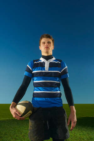 Portrait of young man holding rugby ballの写真素材