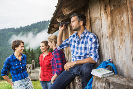 Friends chatting enjoying view through binoculars, Tirol, Austriaの写真素材
