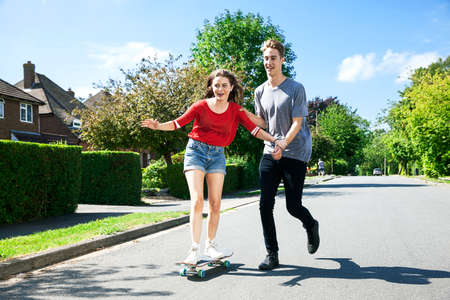 Young couple practicing on skateboardの写真素材