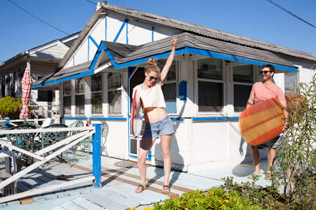 Couple on patio with surfboards, Breezy Point, Queens, New York, USAの写真素材