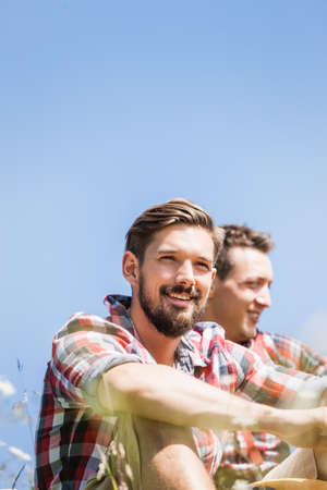 Portrait of two young men against blue skyの写真素材