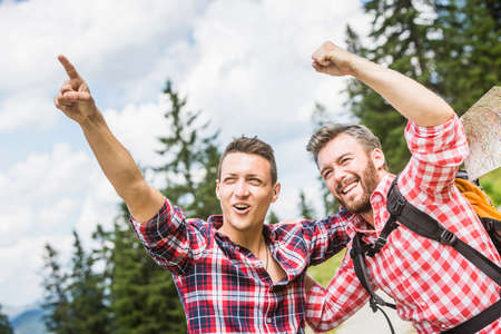 Two male friends pointing and cheeringの写真素材
