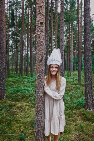 Teenage girl wearing white hat in forestの写真素材