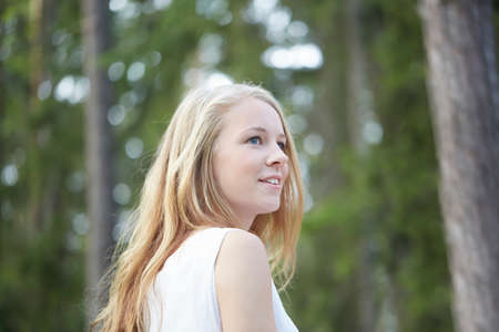 Portrait of teenage girl with long blonde hair looking awayの写真素材