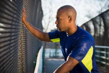 Man resting hand on fence