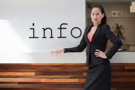 Businesswoman standing at info deskの写真素材