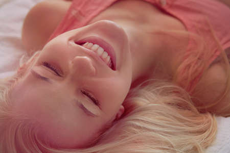 Young woman lying in bedの写真素材