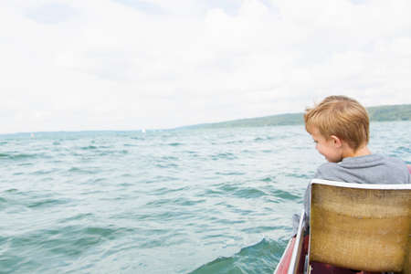 Young boy on pedalo, Lake Ammersee, Bavaria, Germanyの写真素材