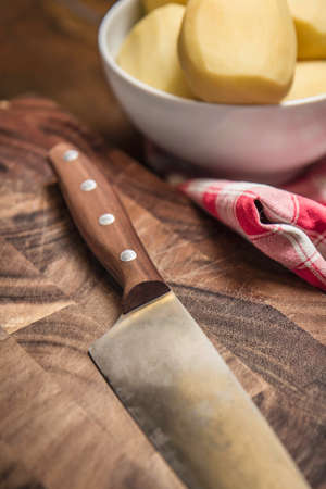 Still life of peeled potatoes in bowl and kitchen knifeの写真素材