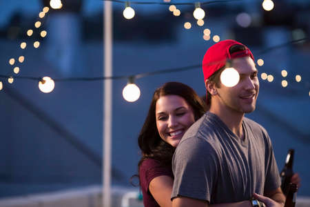 Young couple hugging at rooftop barbecue