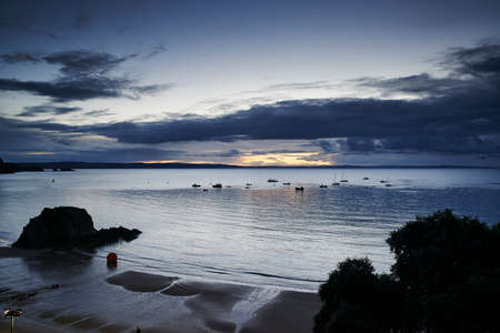 Silhouetted boats and seascape, Tenby, Wales, UKの写真素材