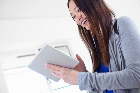 Young woman in kitchen using digital tablet