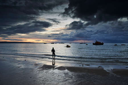 Swimmer on coastline, Tenby, Wales, UKの写真素材