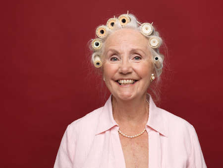 Studio portrait of senior woman in hair rollers