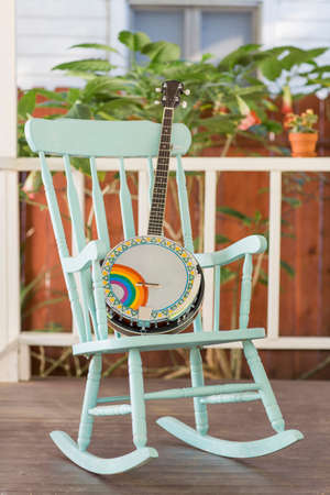 Banjo and rocking chair on outside porchの写真素材