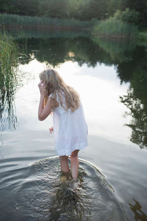 Teenage girl enjoying river in the eveningの写真素材