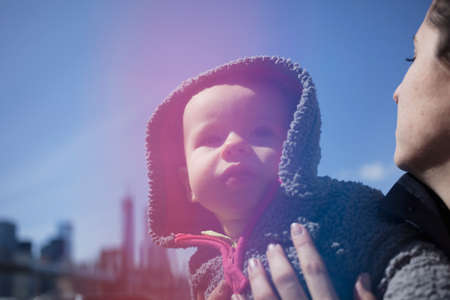 Mother holding daughter wearing hoodの写真素材