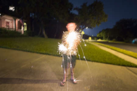 Boy playing with sparklersの写真素材