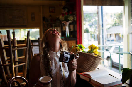 Young woman with camera in cafeの写真素材