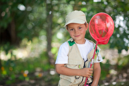 Boy with red fishing netの写真素材