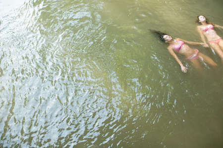 Friends floating in waterの写真素材