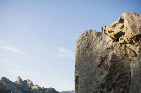 Male,and female climbers on top of "Tribal Boundaries" 5.10a - Flaming Rock, City of Rocks, Idaho, USAの写真素材
