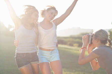 Young female friends posing for photographsの写真素材
